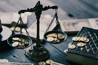 Scales of justice with coins, symbolizing financial decisions in Georgia settlements or trials.