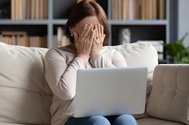 Woman researching wrongful death lawsuits on a laptop, seeking legal guidance for her family.