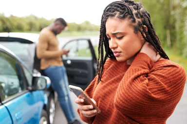 Two individuals at car accident scene, illustrating negligence in personal injury law.