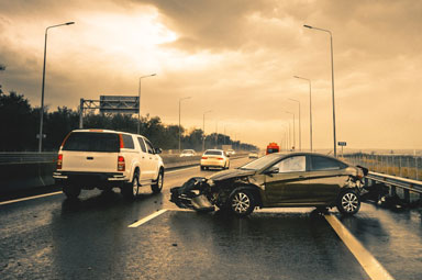White SUV and dark sedan in highway crash, highlighting causes of accidents in Georgia.